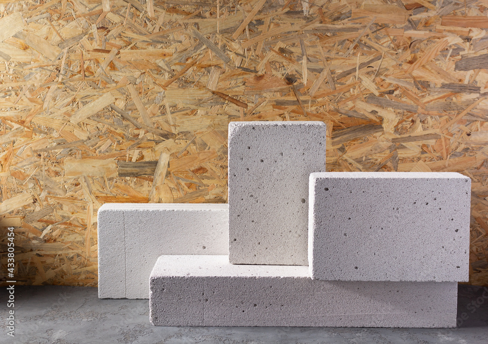 Aerated concrete block cube or bricks near osb wall background texture. Construction concept