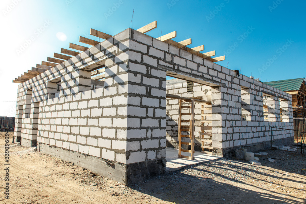 Building site of a house under construction. corner unfinished house walls made from white aerated autoclaved concrete aac blocks
