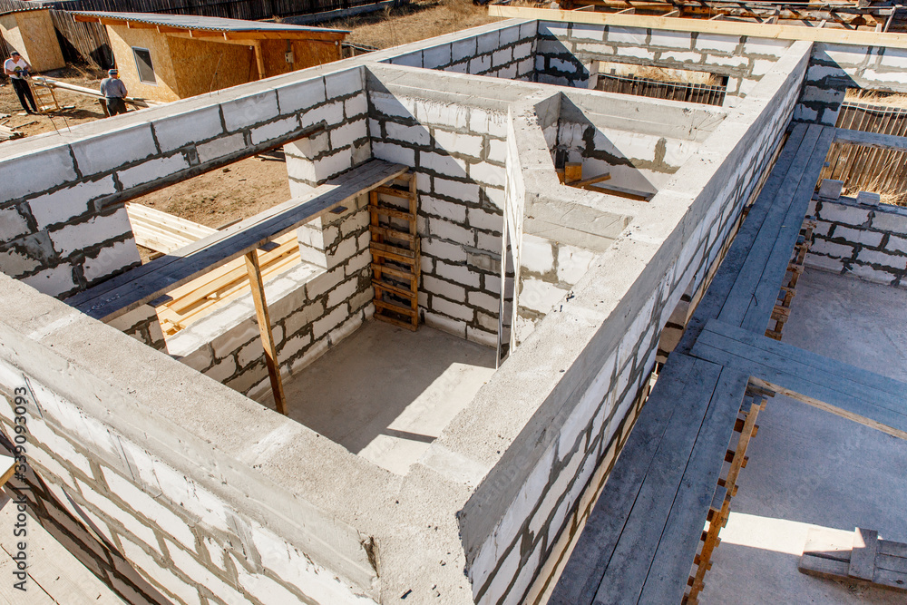 cost-effective advantages of Under construction house walls made from white aerated autoclaved concrete blocks. Woods elements and components of the construction of roof. Ceiling beams of natural eco-friendly materials. top view